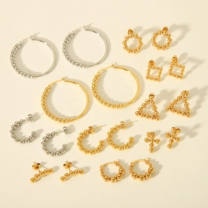 Flat lay of beaded gold and silver titanium steel stud earrings in geometric shapes