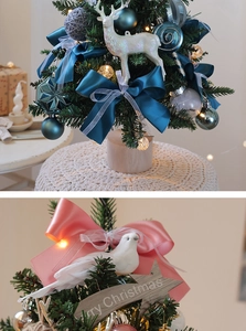 Detailed view of mini Christmas tree with blue bows, white deer and LED lights