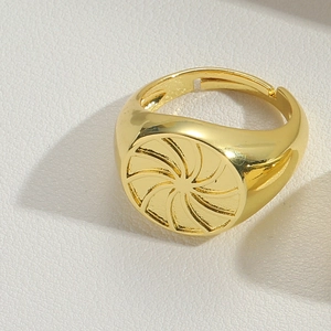 Detailed close-up of a golden adjustable ring featuring a textured swirl flower motif