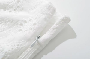 Detailed macro shot of white lace embroidery and invisible zipper on the mini skirt