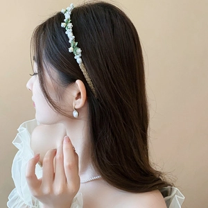 Détail latéral du serre-tête floral avec perles et ornements de muguet élégants