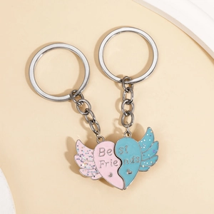 Detail of magnetic Best Friends winged heart keychain with pink and blue glitter finish