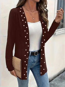 Detail of dark brown knit cardigan featuring elegant white pearl bead trim and ribbed texture