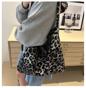Détail d'un grand sac cabas à motif léopard en maille porté comme sac à bandoulière