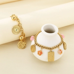 Detailed close-up of vintage gold bracelets with evil eye and portrait charms