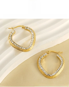 Macro detail of gold plated heart earring with Greek key pattern and cubic zirconia