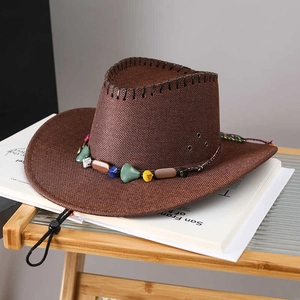 Détail d'un chapeau de paille marron foncé avec des perles ethniques et une mentonnière réglable