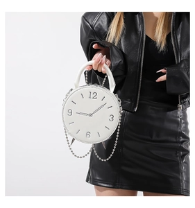White clock-shaped PU handbag with metal chain detail shown on a fashion model