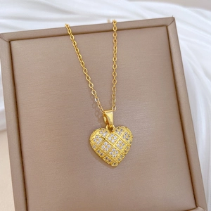 Dettaglio della collana cuore oro con motivo griglia e zirconi su portagioie