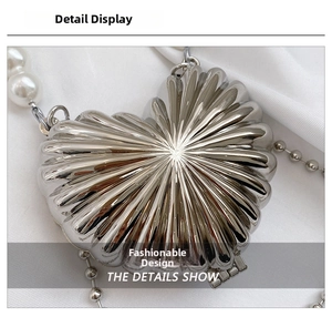 Detailed close-up of heart-shaped silver metal evening bag with pearl bead chain