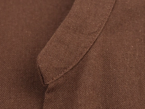 Detail view of the fine stitching and linen texture on a dark brown v-neck dress