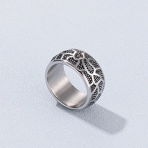 Close-up of vintage wide stainless steel ring featuring black animal print totem patterns