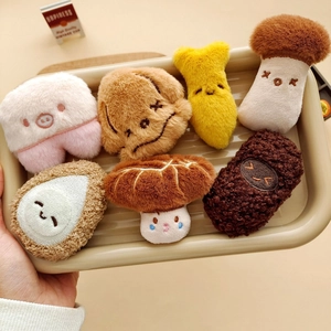 Plush food pins set with cute mushrooms, rice balls, and drumsticks in a wooden tray