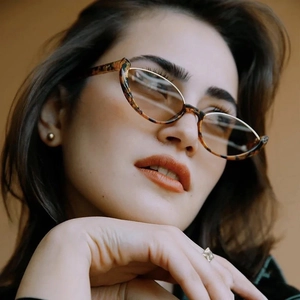 Close-up of tortoise shell cat-eye sunglasses on a model with a retro fashion style