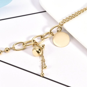 Bracciale in acciaio al titanio dorato con ciondolo a zucca e nappina in metallo