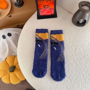 Close-up of blue coral fleece Halloween socks with pumpkin and ghost themed decor