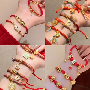 Bracelets traditionnels en corde rouge avec breloques dorées et détails tressés
