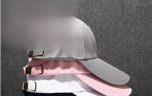 Detailed view of stacked cotton baseball caps with long brims and metal buckles