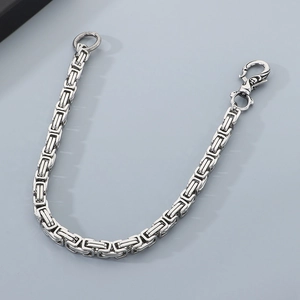 Detailed view of silver Byzantine chain with ornate lobster clasp and metallic finish