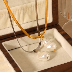 Pendentif perle baroque sur chaînes dorées 18K et argentées dans un écrin à bijoux en bois