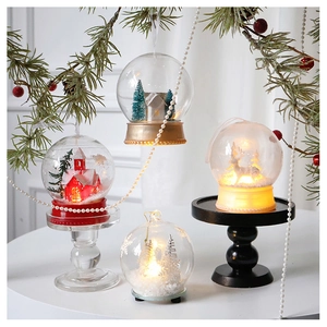 Detailed view of LED lighted Christmas snow globes with winter forest and reindeer scenes