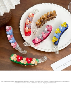 Detail of floral acetate banana clips with gradient petals and sparkling rhinestones