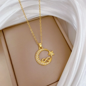 Detail of gold star and moon necklace with crystal infinity pendant in jewelry box