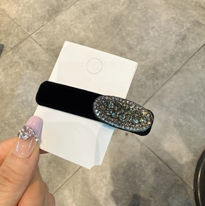 Dettaglio dell'elegante fermaglio per capelli in velluto nero con strass brillanti