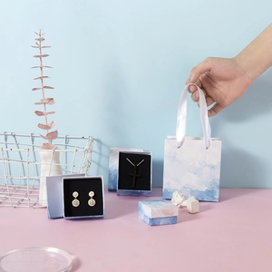 Cloud pattern jewelry gift set with paper bag and multiple sized boxes on pastel surface
