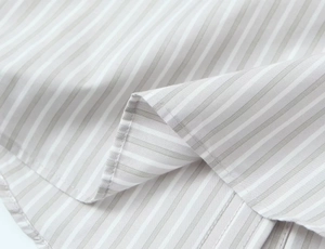 Détail du tissu rayé gris et blanc montrant des coutures fines et une texture en coton