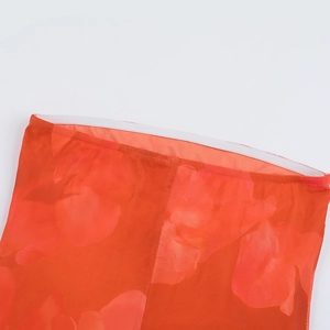 Détail du tissu en maille orange rouge avec coutures sur la taille élastique de la robe