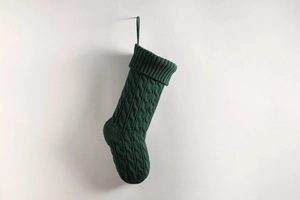 Close-up of green cable knit Christmas stocking showing detailed texture and hanging loop