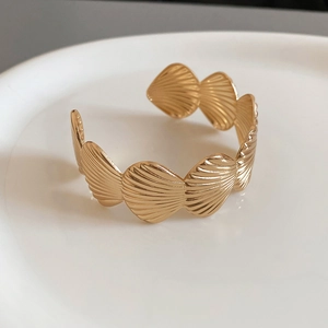 Detail shot of golden starfish ruffled shell bracelet with fine textured stripes