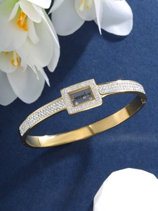 Macro shot of gold bracelet with white crystals and Forever love engraving