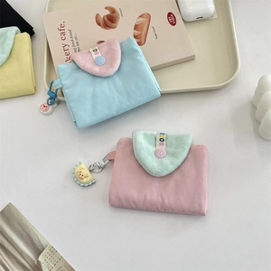 Détail montrant deux porte-cartes pastel avec rabats en peluche et porte-clés oursons