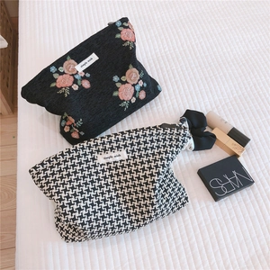 Flat lay of vintage floral jacquard and houndstooth makeup bags with zipper closure