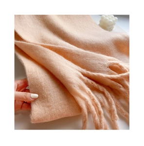 Close-up of soft peach mohair scarf showing thick texture and long fringe tassels