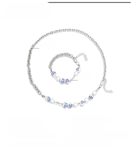 Macro detail of blue and white porcelain beads on a stainless steel chain necklace set