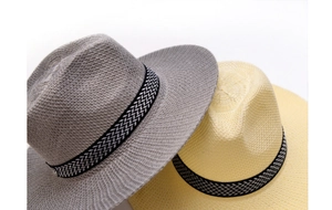 Detailed macro view of woven straw sun hats in grey and beige with textured bands