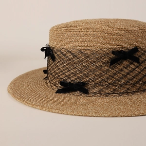 Detail of boater hat with black mesh veil and velvet bows in French vintage style