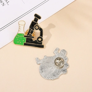Detailed view of science enamel pin showing microscope design and butterfly clasp back