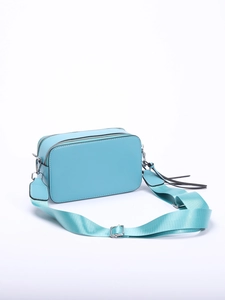 Detail view of light blue crossbody bag with double zippers and wide adjustable strap
