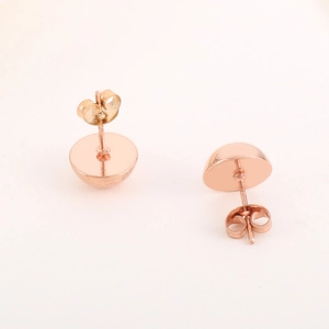 Detail view of rose gold hollow semi-circular stud earrings with polished metallic finish
