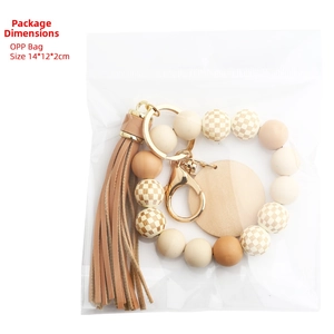 Close-up of checkerboard wood bead keychain with leather tassel in packaging