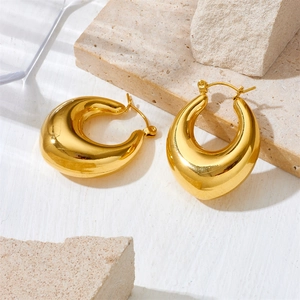 Close-up of chunky gold hoop earrings with polished finish on decorative stones