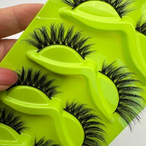 Dramatic cat-eye false eyelashes in voluminous black fiber on green display tray