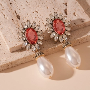 Macro shot of vintage baroque drop earrings with red crystal flower and pearl details