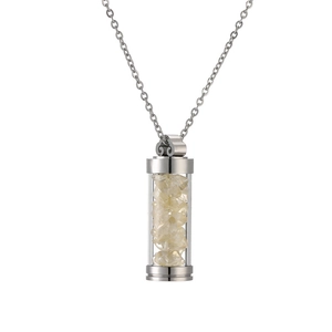 Detail of silver perfume bottle pendant filled with yellow crystals on a delicate chain