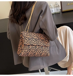 Détail du sac en toile à imprimé léopard avec bandoulière chaîne dorée sur mannequin
