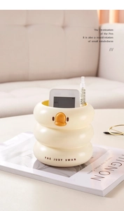 Close-up of yellow duck desk organizer with tiered design holding pens and calculator